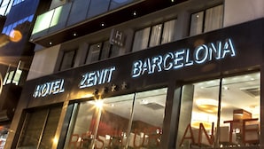 Un hotel de varios pisos con balcones y ventanas amplias.