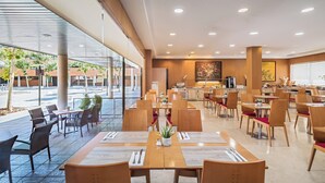 A modern restaurant with indoor and outdoor seating, large windows, and a clean, contemporary design. - Sercotel de los Reyes (San Sebastian de los Reyes)