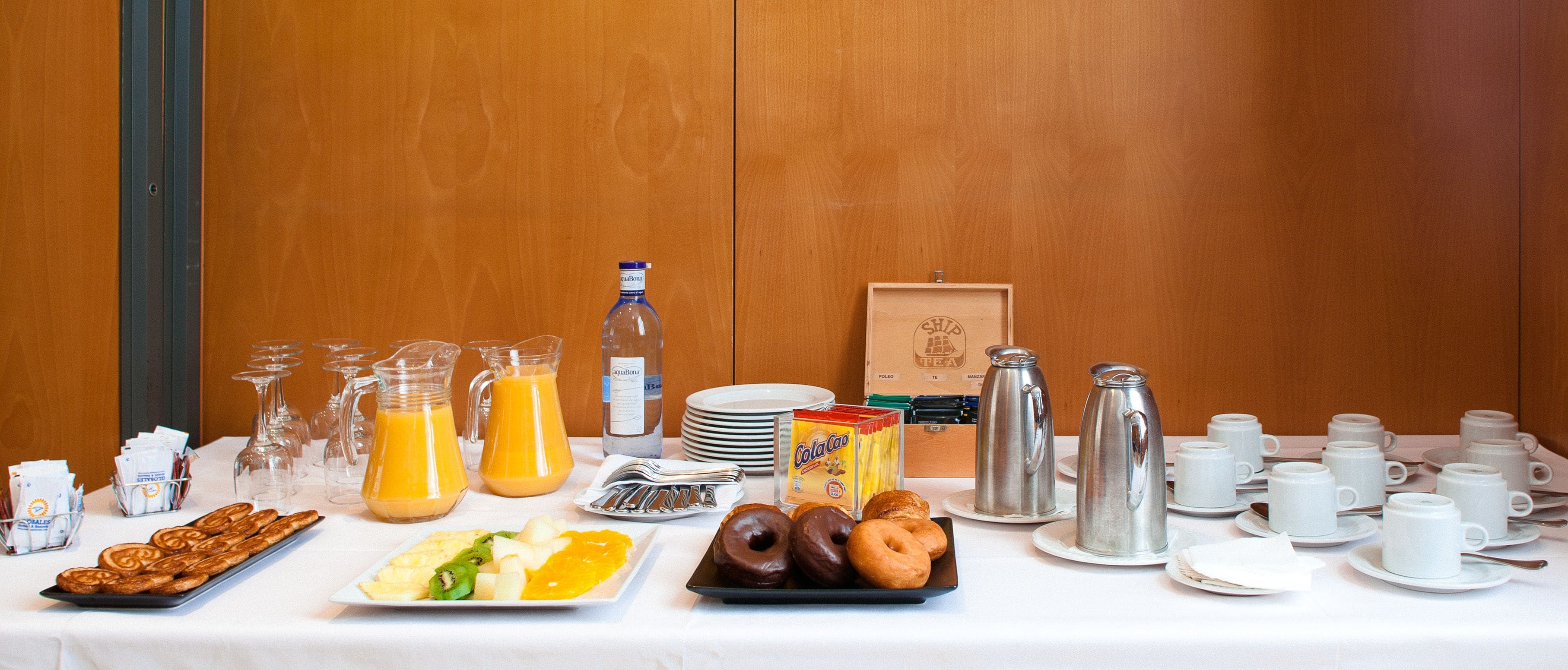 En morgenmadsbuffet med forskellige retter, drikkevarer og spiseartikler.