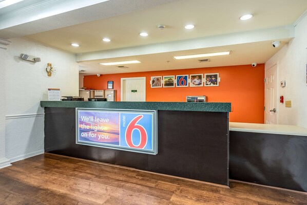 A reception desk with a sign reading "We'll leave the light on for you."