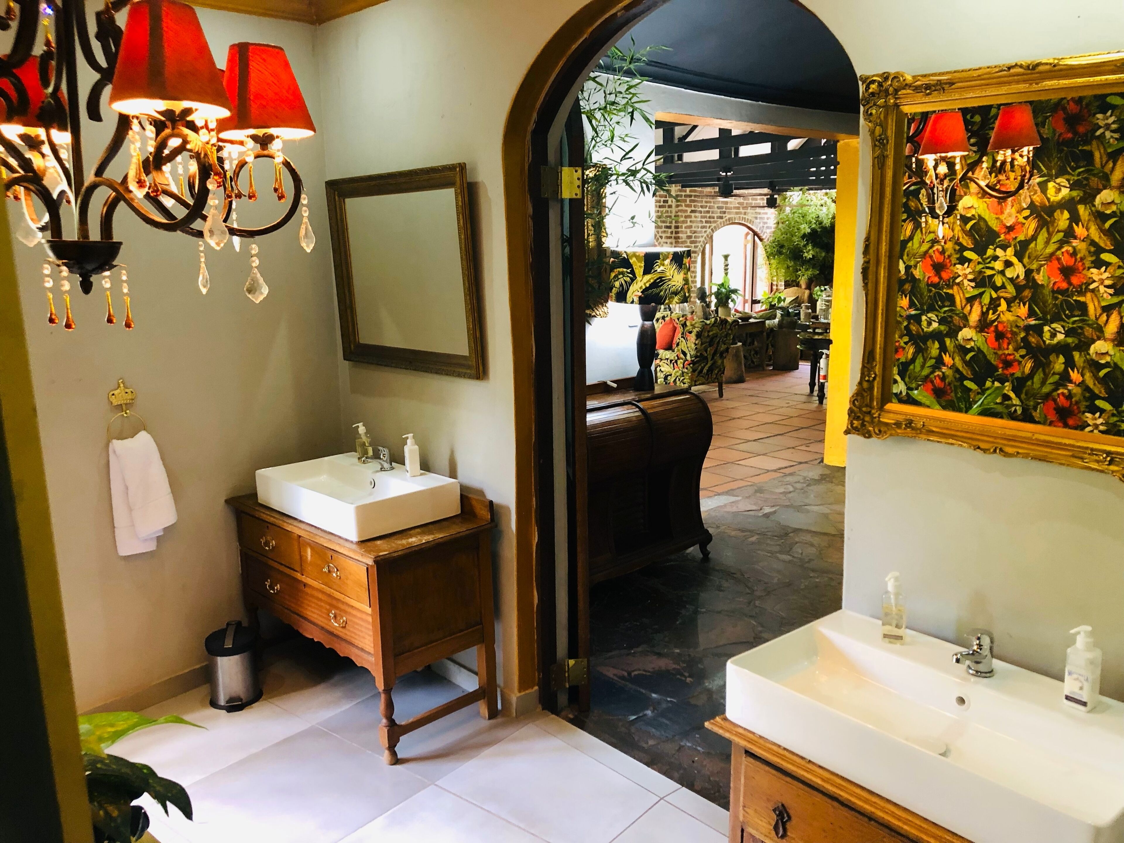 A bathroom with two sinks, a mirror, and a chandelier.