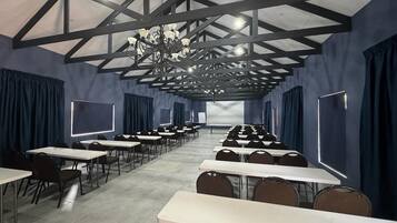 Un salón de conferencias con mesas y sillas, una pantalla de proyector y una araña.