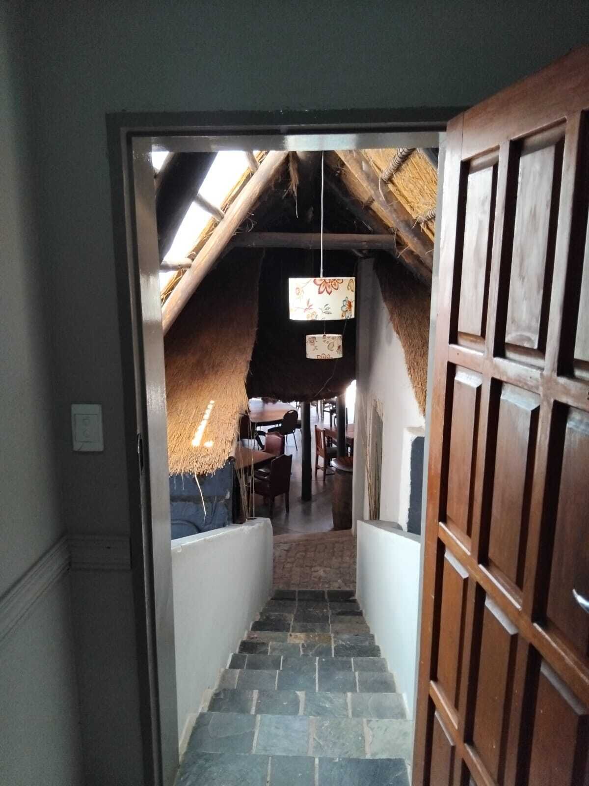 A narrow stone staircase leading to a room with a sloped ceiling and a hanging light fixture.