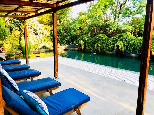 Alberca al aire libre, sombrillas en la alberca y camastros 