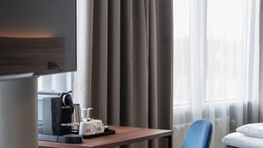 A hotel room with a wooden desk, a coffee maker, two mugs, a TV, and a window with curtains. - Thon Hotel Stavanger Forum (Stavanger)