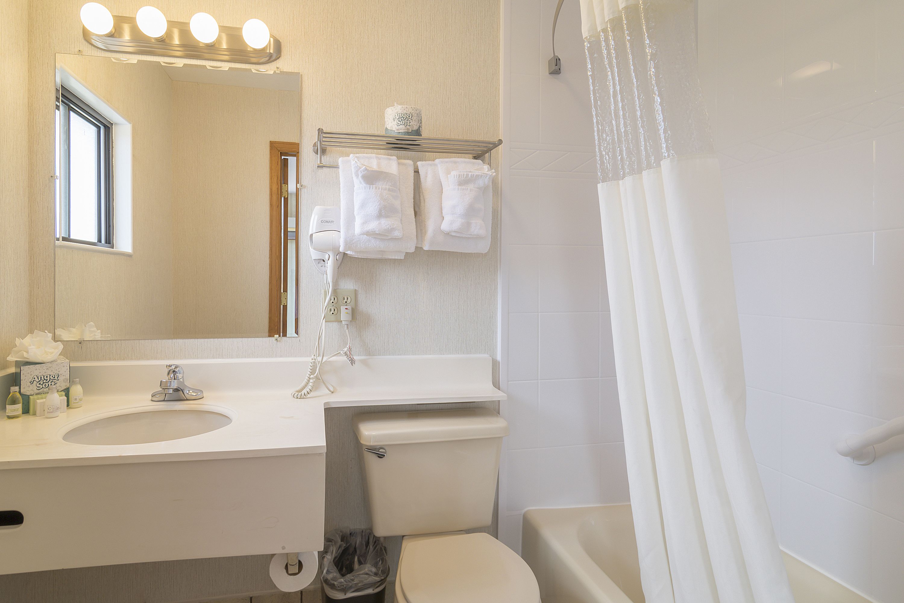 A bathroom with a sink, mirror, and toilet.