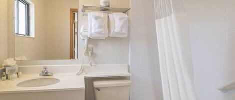 A bathroom with a sink, mirror, and toilet.