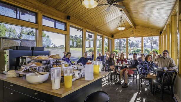 A restaurant with a wooden interior, large windows, and a buffet setup. - Blue Door Inn (Estes Park)