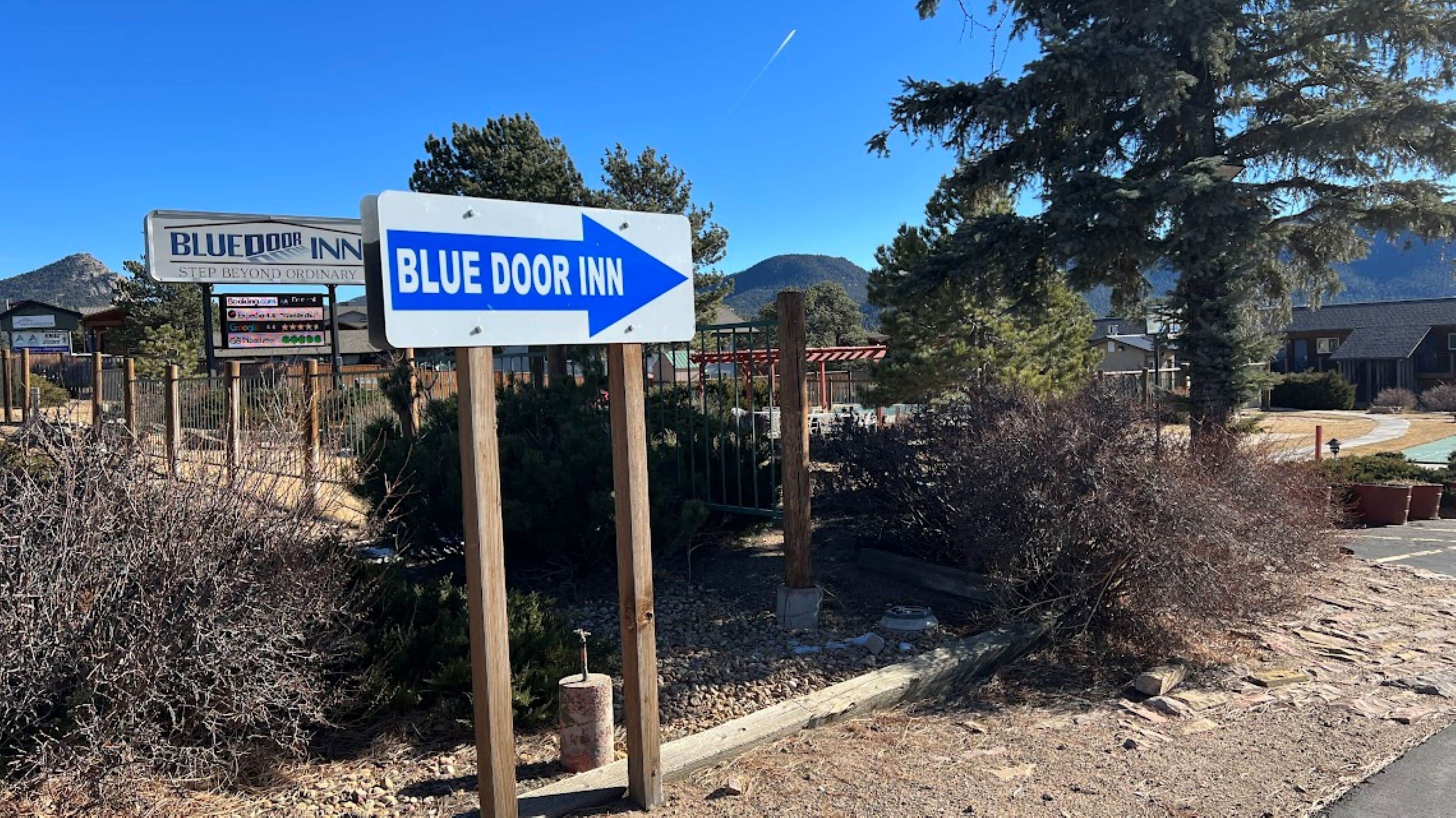A sign for Blue Door Inn with a directional arrow.