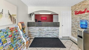 A reception area with a Red Roof Inn sign, a fish-themed display, and a water dispenser.