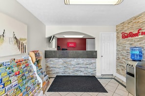 A reception area with a Red Roof Inn sign, a fish-themed display, and a water dispenser.