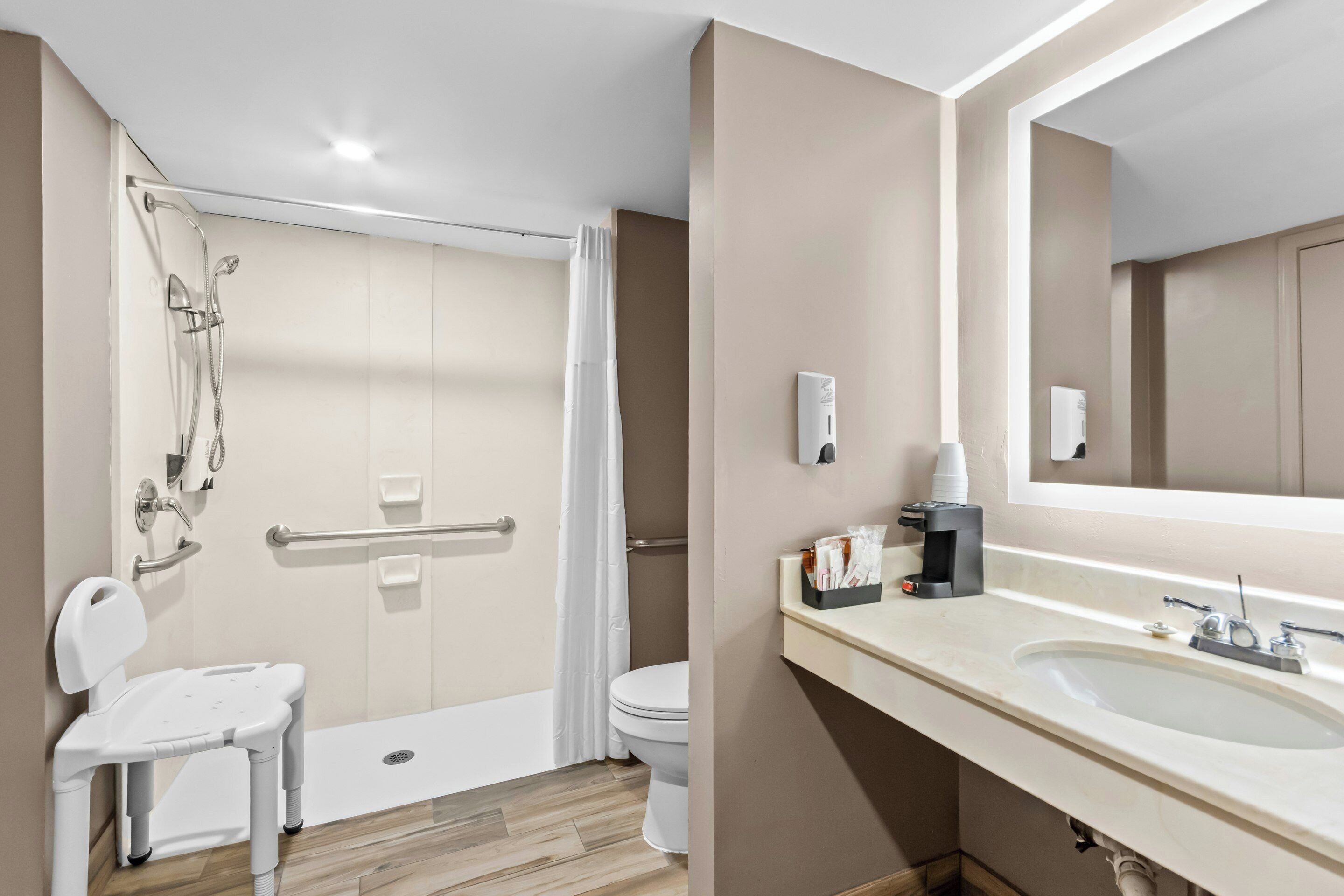 Une salle de bain avec douche, toilettes et lavabo.