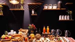 Um buffet de café da manhã com diversos alimentos, bebidas e elementos decorativos.
