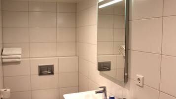 Een badkamer met een wit wastafel, een spiegel en een toilet.