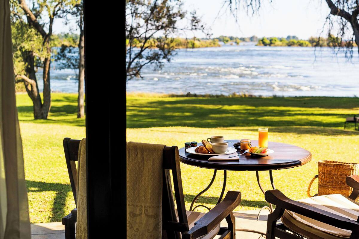 Ein Tisch mit Frühstücksangebot und Blick auf einen See.