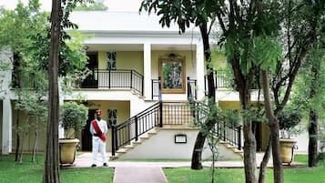 A two-story building with a central staircase, a large planter, and a uniformed staff member.