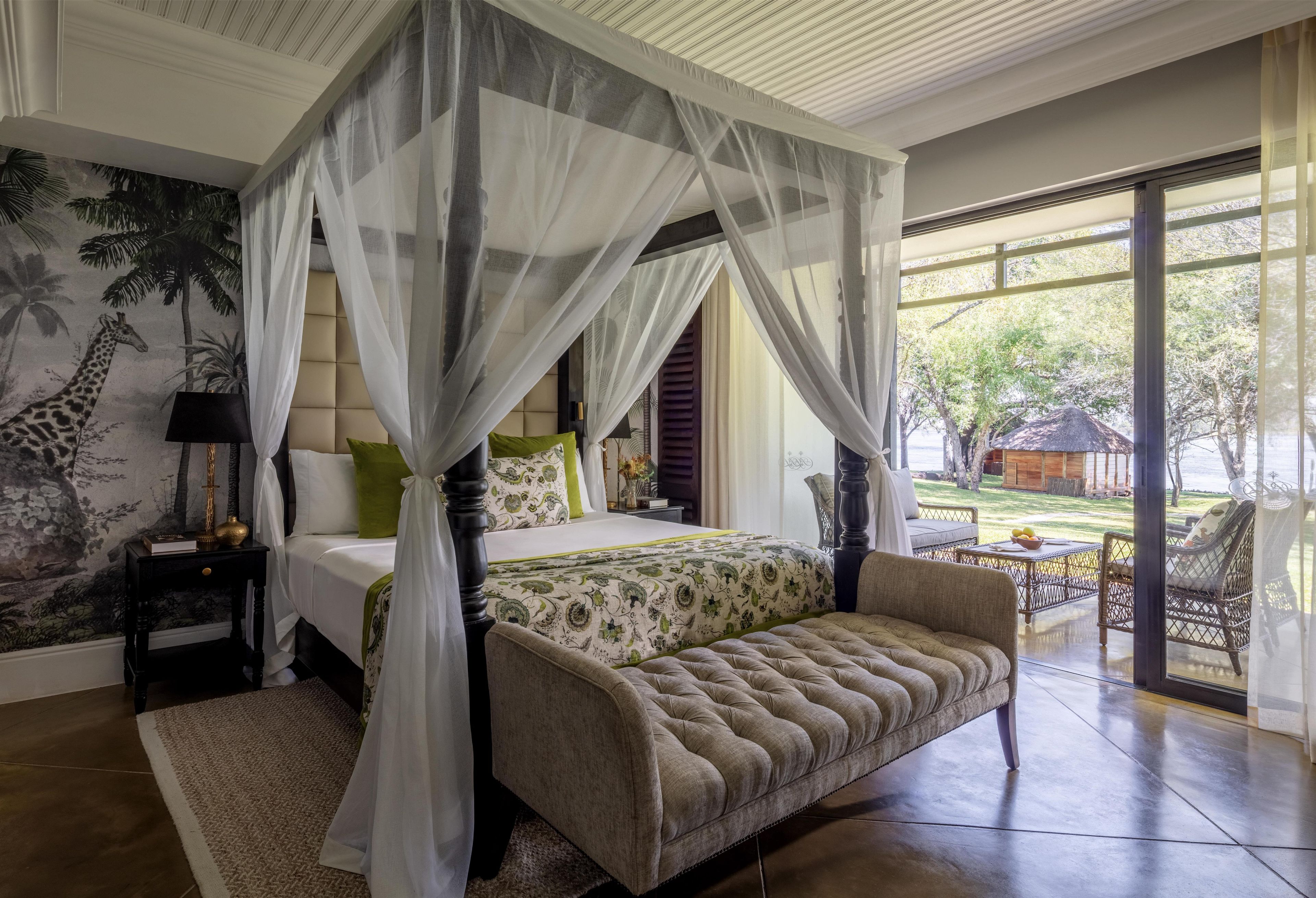 A four-poster canopy bed with a view of the outdoors.