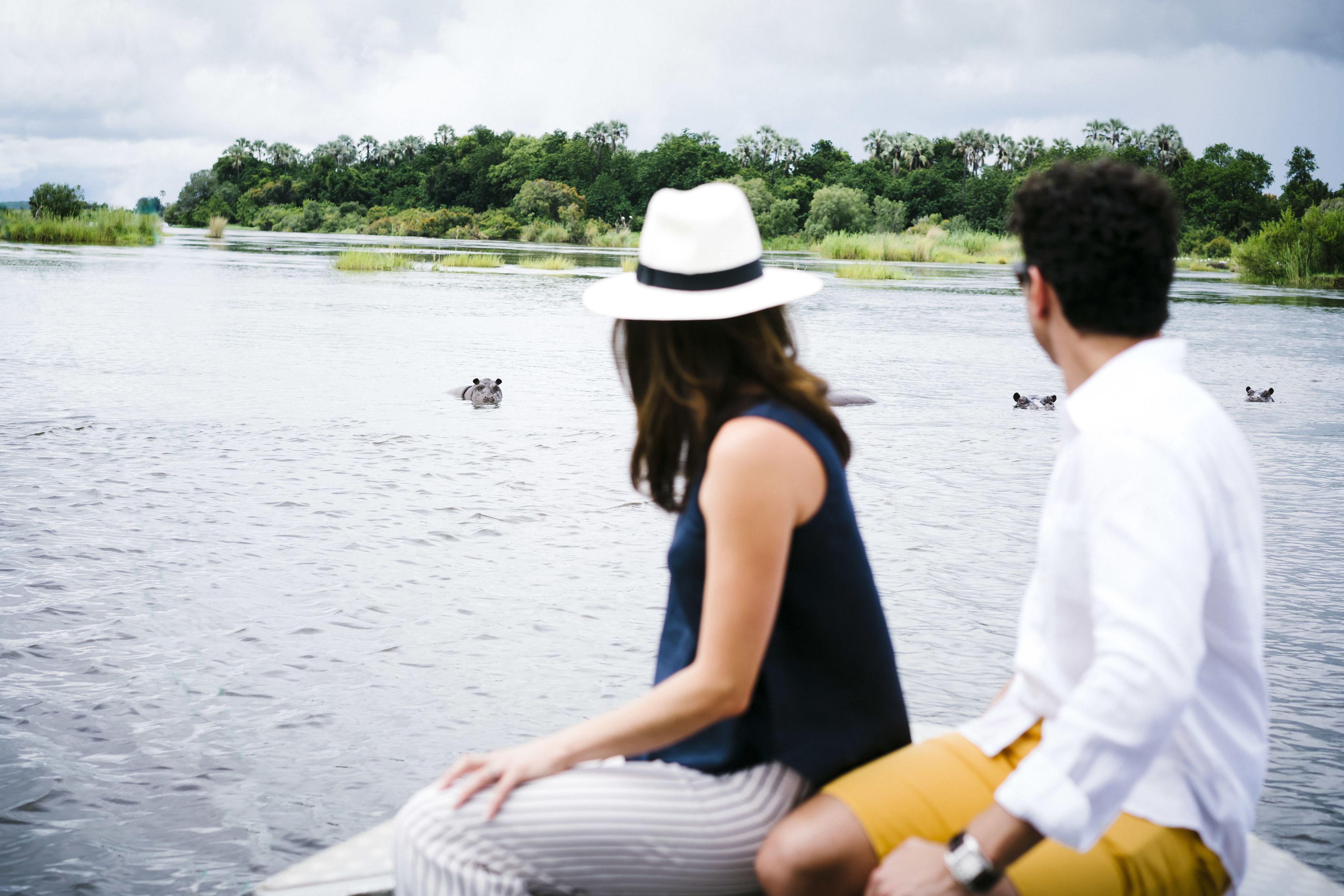 Una pareja sentada en un bote en un río rodeado de vegetación.