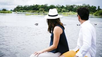 Una pareja sentada en un bote en un río rodeado de vegetación.