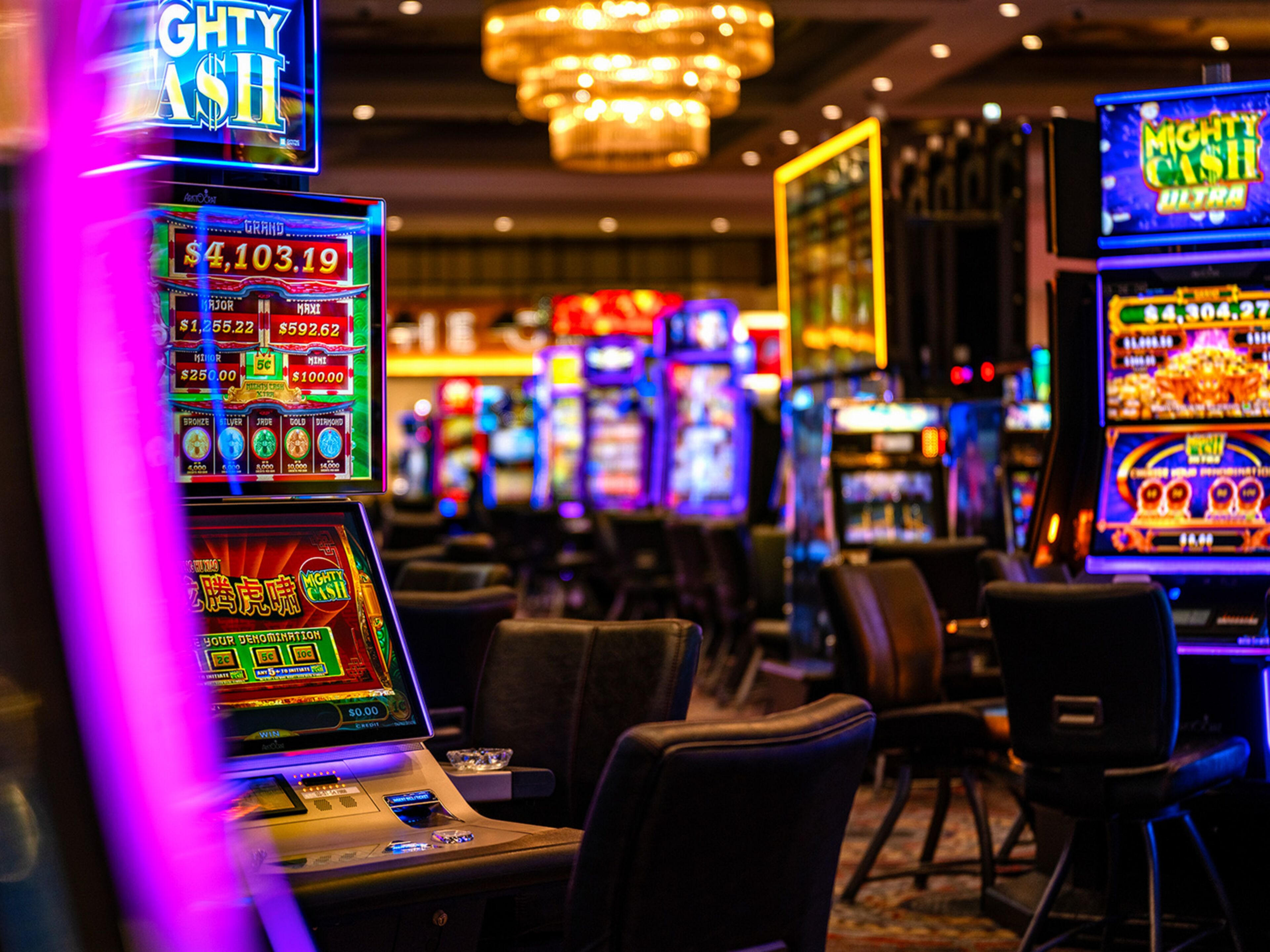 Un casino con máquinas tragamonedas y una araña de cristal.