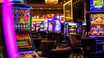 Un casino con máquinas tragamonedas y una araña de cristal.