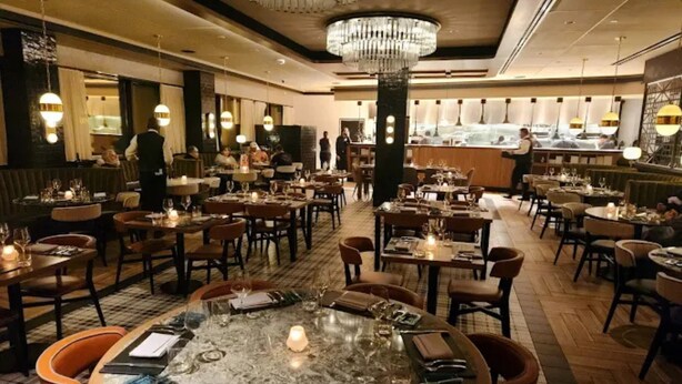 A restaurant with round tables, chairs, chandeliers, and a bar area. - Caesars Southern Indiana Hotel & Casino - A Caesars Rewards Destination (Elizabeth)