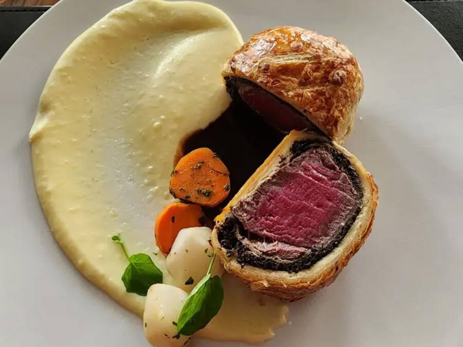 Un plato con un pastel, carne de res y verduras.