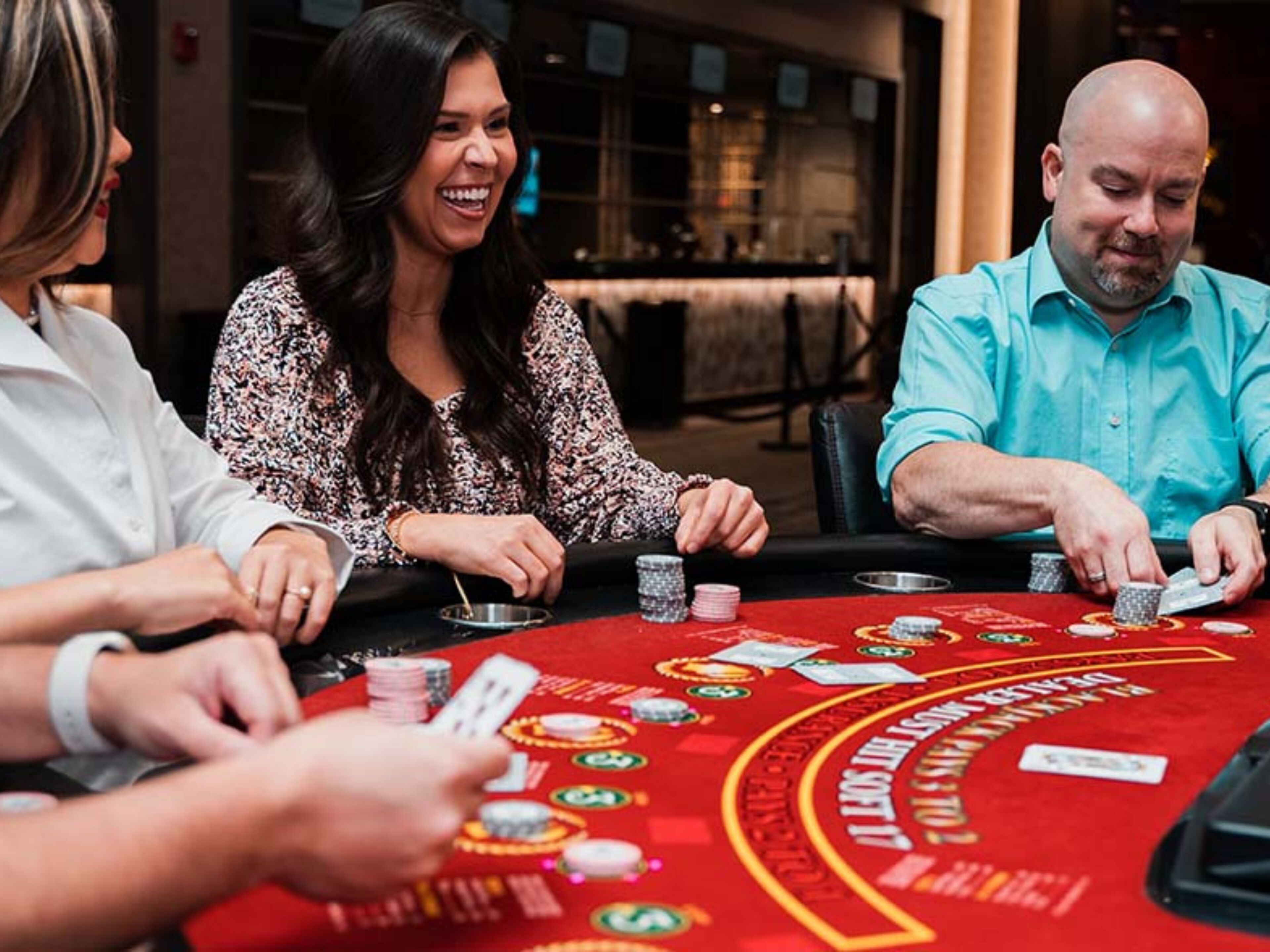 A group of people playing blackjack at a casino table.