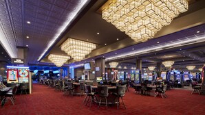 A casino with multiple gaming tables and slot machines, a red carpet, and ornate chandeliers. - Caesars Southern Indiana Hotel & Casino - A Caesars Rewards Destination (Elizabeth)