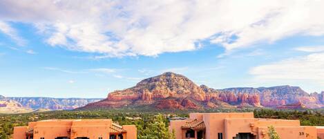 A desert landscape with a mountain in the background and two buildings in the foreground.