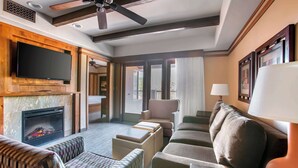 A spacious living area with a fireplace, comfortable seating, a flat-screen TV, and a ceiling fan. - Hilton Vacation Club Sedona Summit (Sedona)
