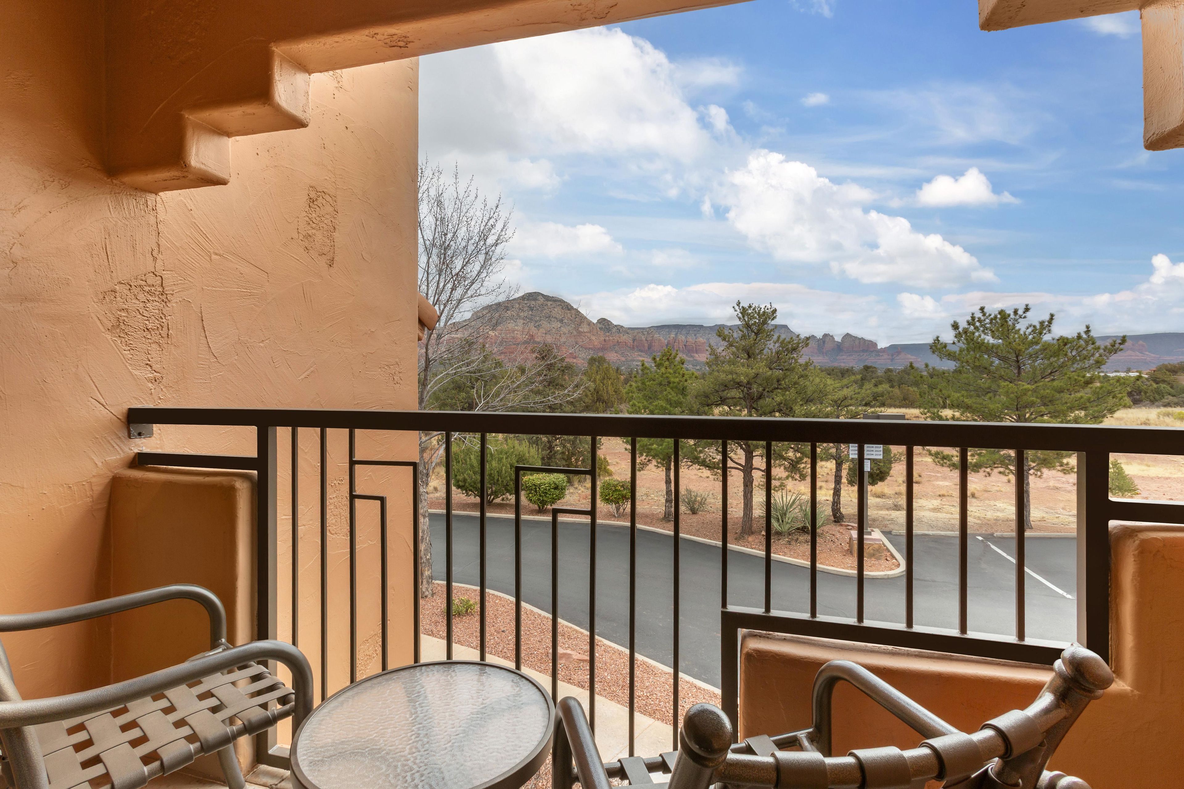 A balcony with a view of a road and mountains.