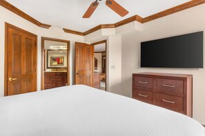 A bedroom with a large bed, wooden wardrobe, a flat-screen TV, and a ceiling fan. - Hilton Vacation Club Sedona Summit (Sedona)