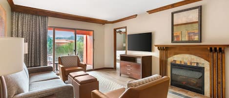 A modern living room with a fireplace, comfortable seating, and a television.