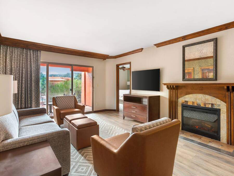 A modern living room with a fireplace, comfortable seating, and a television.
