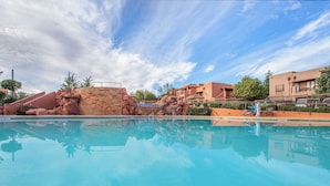 A clear swimming pool with a stone structure in the background, surrounded by buildings. - Hilton Vacation Club Sedona Summit (Sedona)