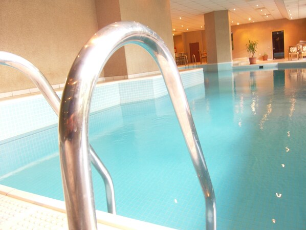 A swimming pool with clear blue water and metal pool ladders. - Apart Hotel Best (Ankara)