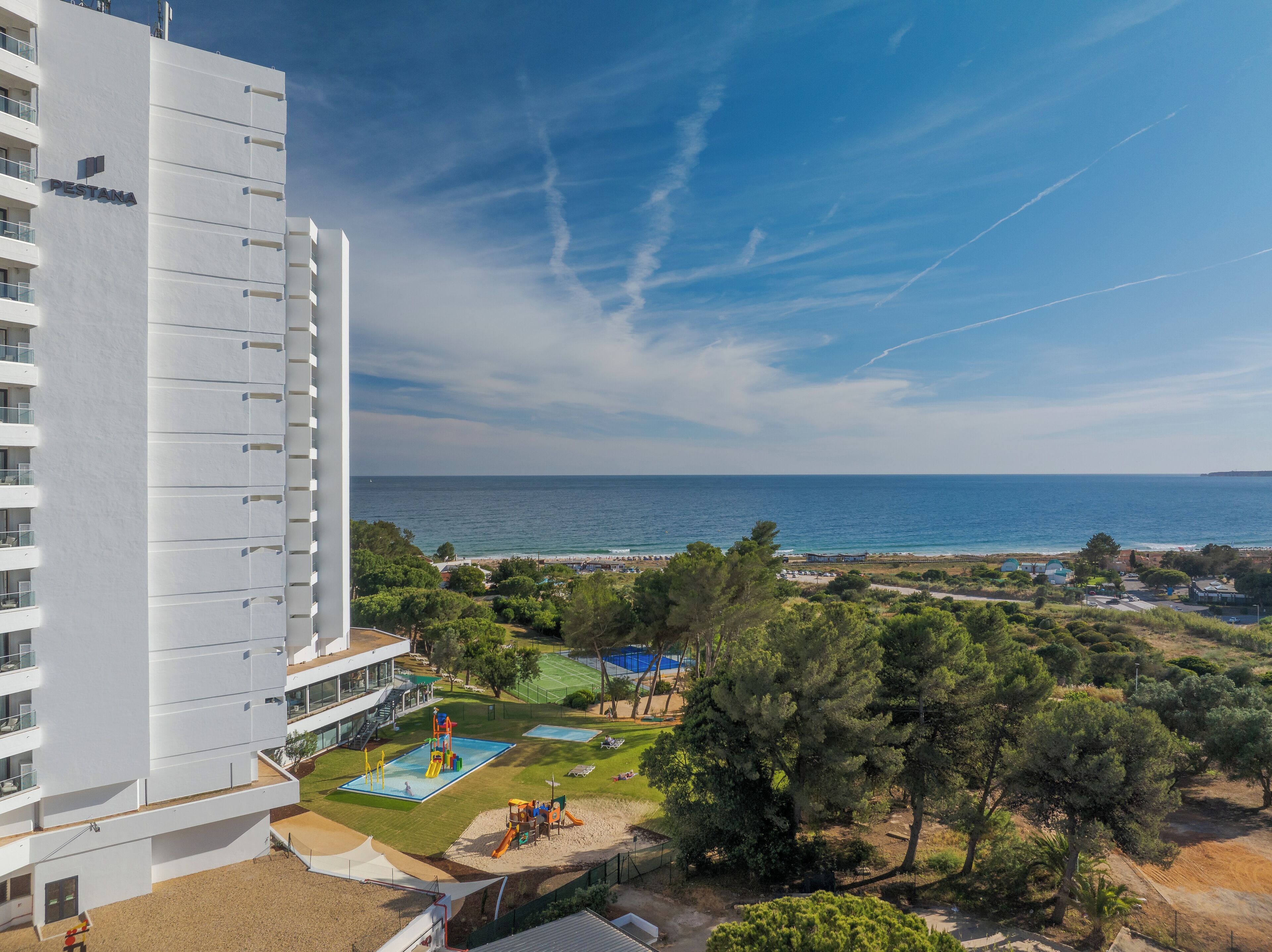 Un immeuble de grande hauteur doté d’une piscine sur le toit et offrant une vue sur la mer.