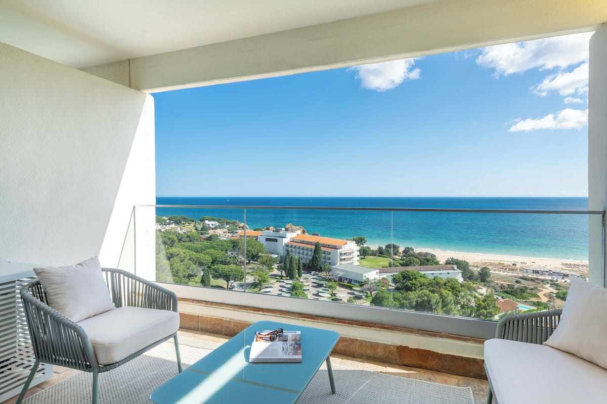 A balcony with a view of the sea and buildings.