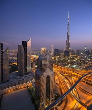 A cityscape with modern skyscrapers, including a prominent tower, and a complex highway interchange. - Dusit Thani Dubai (Dubai)