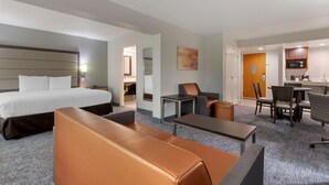 A hotel room with a large bed, a sofa, a desk, a chair, and a small kitchenette. - Best Western Plus McAllen Airport Hotel (McAllen)