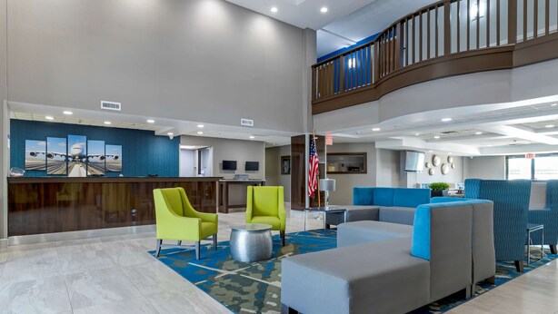A spacious lobby with a reception desk, seating area, and a staircase to an upper level. - Best Western Plus McAllen Airport Hotel (McAllen)