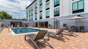 Una piscina al aire libre de temporada, sillones reclinables de piscina