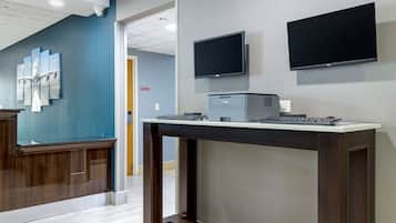 A reception desk with a computer, a flat-screen monitor, and a printer.