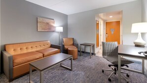 A modern hotel room with a sofa, a small table, a chair, and a desk. - Best Western Plus McAllen Airport Hotel (McAllen)