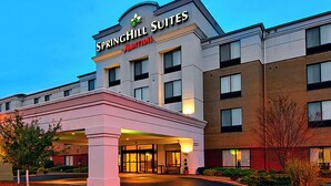 Ett SPRINGHILL SUITES-hotell som tillhör Marriott-kedjan, med en framträdande entré, många fönster och en välanlagd trädgård framför hotellet.