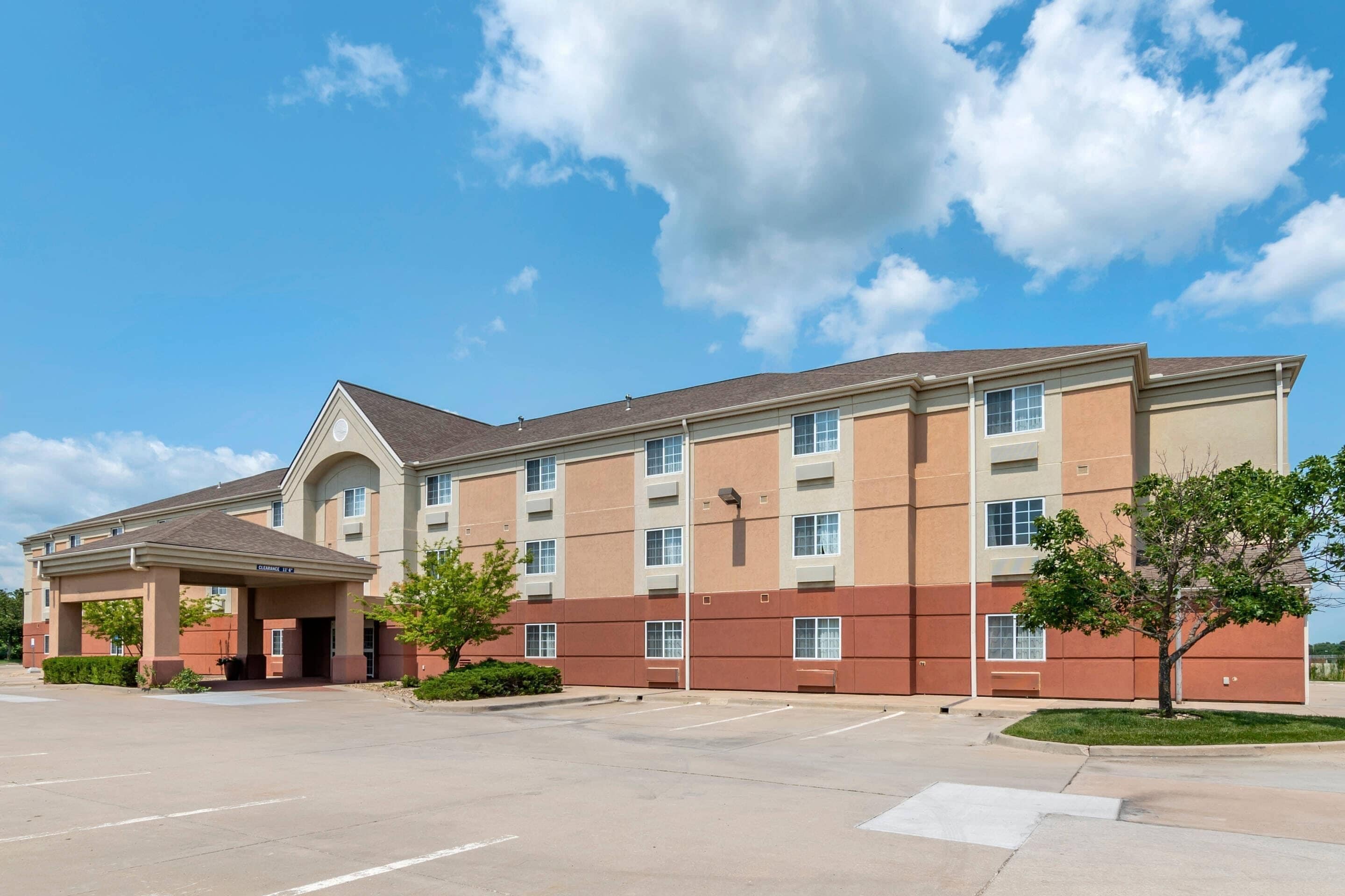A multi-story hotel with a covered entrance and a parking lot.