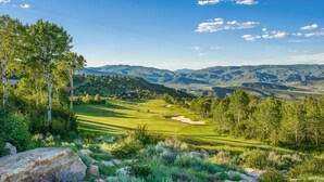 Un campo de golf con colinas onduladas y cielo despejado.