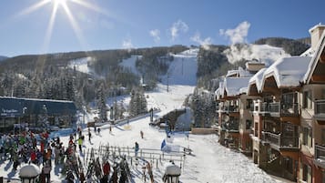 Ein Skigebiet mit Seilbahn, schneebedeckten Bäumen und Gebäuden mit Balkonen.