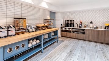 Ein modernes Café mit Holztresen, Regalen mit Optionen für haltbare Milchprodukte und Sojamilch sowie einer Kaffeestation mit diverser Brühapparatur.